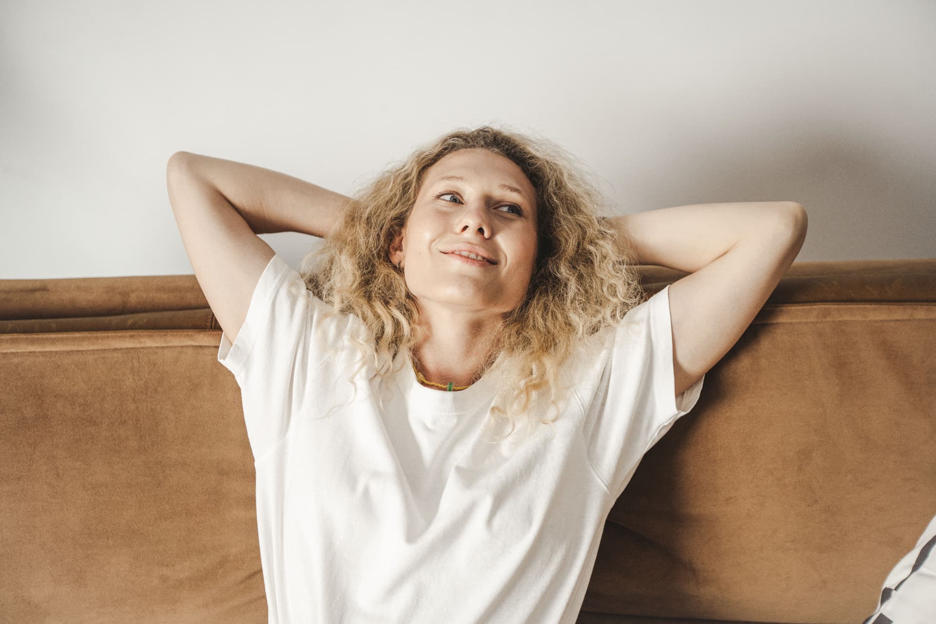 A woman relaxing at home with a hopeful expression